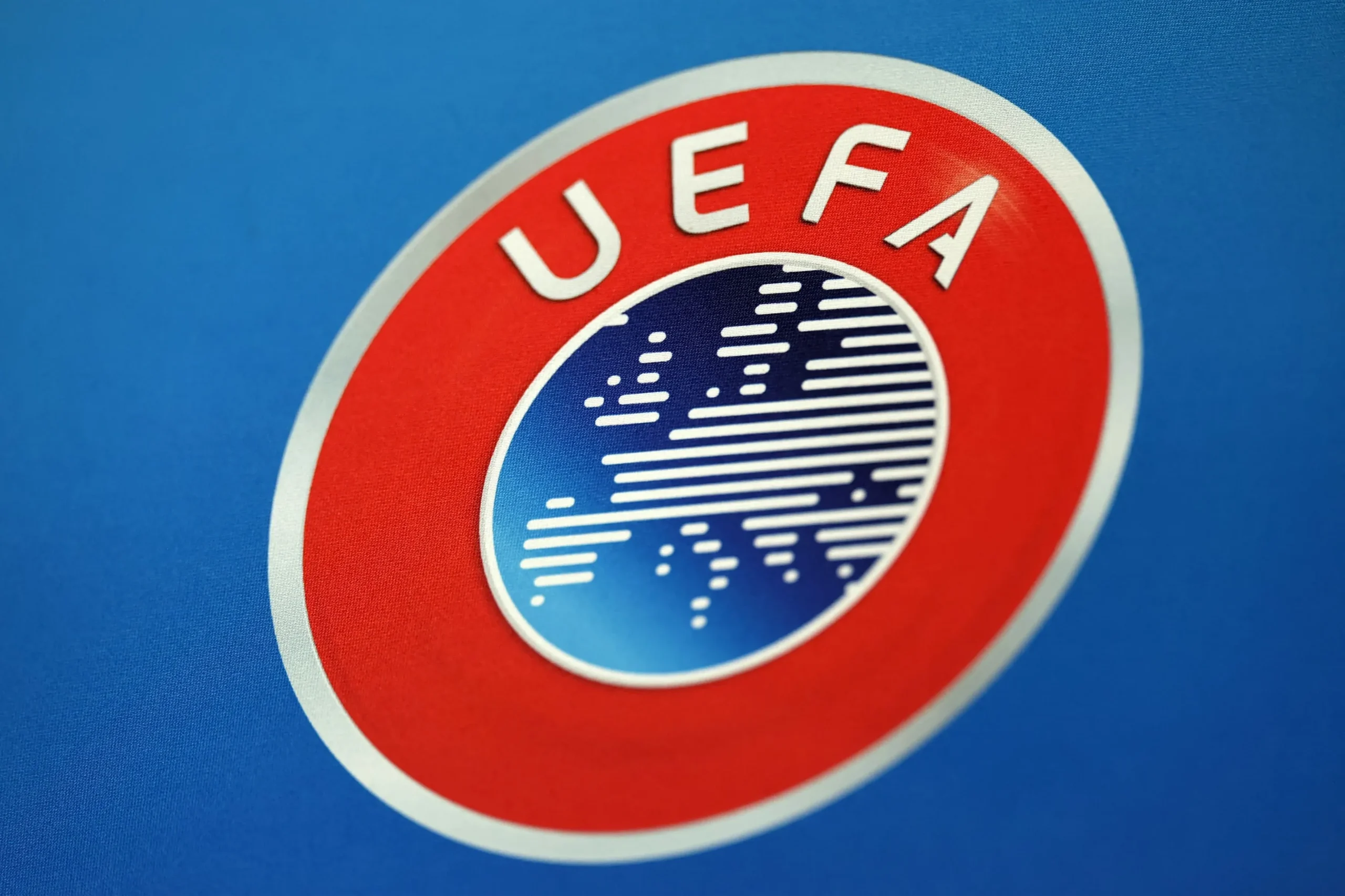 Λογότυπα της UEFA και της FIFA με φόντο γήπεδο