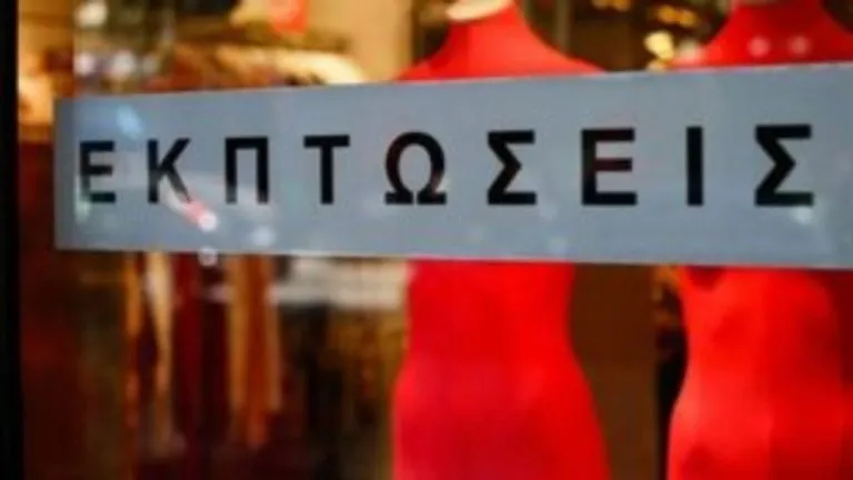 Βιτρίνα καταστήματος με πινακίδα θερινών εκπτώσεων