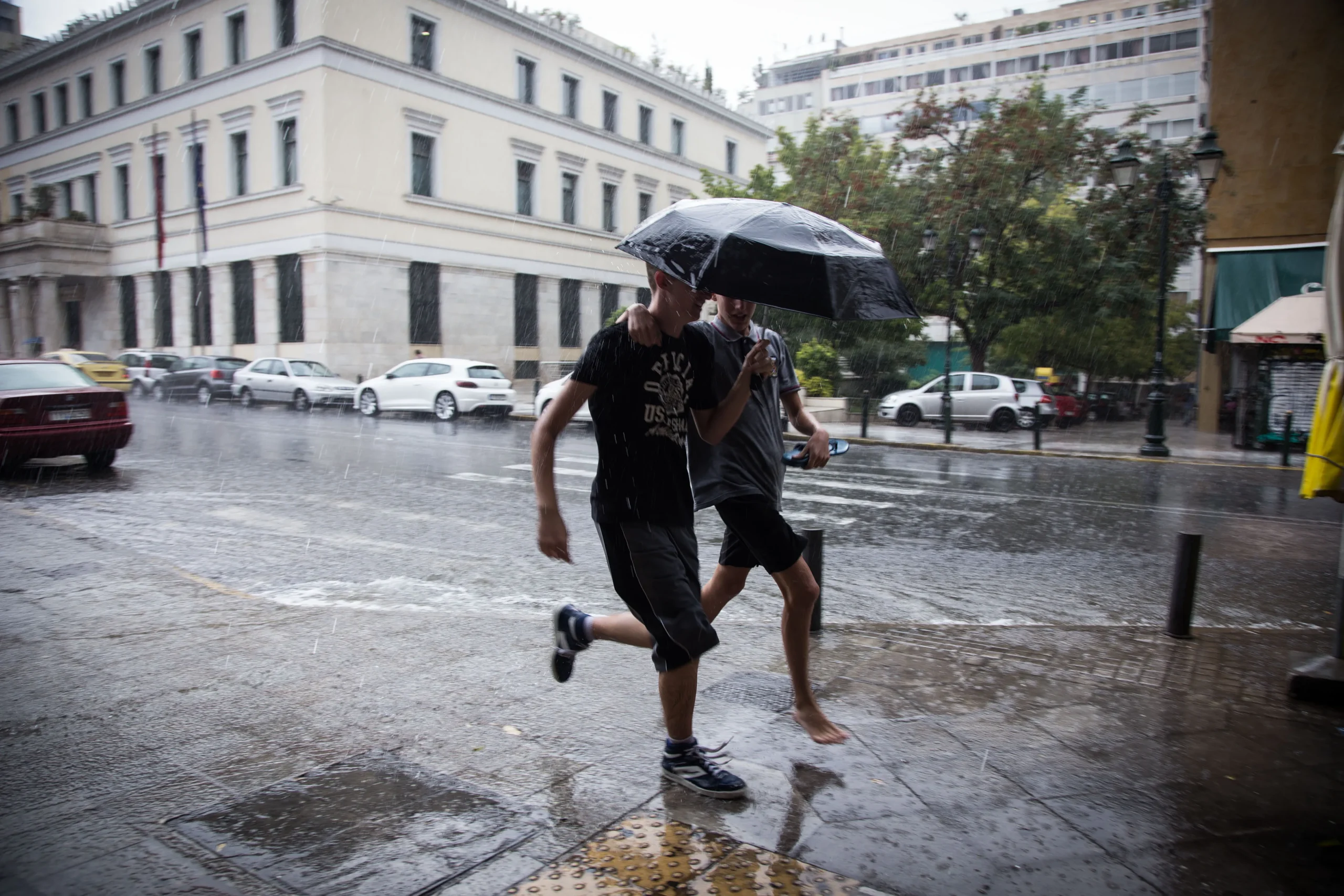 Σύννεφα καταιγίδας και αστραπές πάνω από ελληνική πόλη