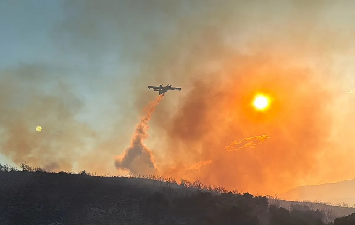 Πυροσβεστικό ελικόπτερο ρίχνει νερό σε δασική πυρκαγιά