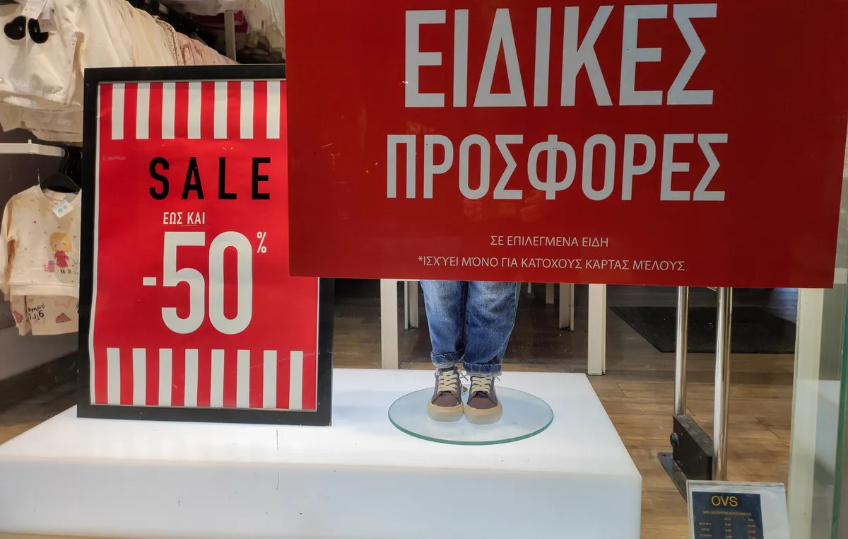 Βιτρίνα καταστήματος με πινακίδα θερινών εκπτώσεων