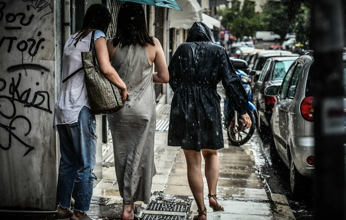 Σύννεφα καταιγίδας και αστραπές πάνω από ελληνική πόλη