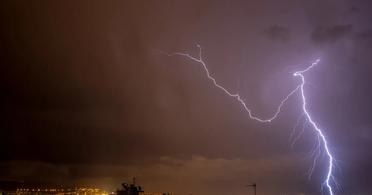 Σύννεφα καταιγίδας και αστραπές πάνω από ελληνική πόλη