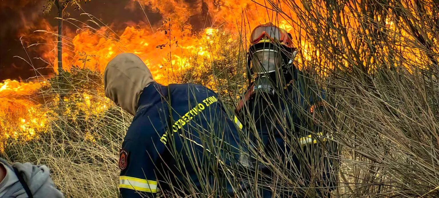 Πυροσβέστες επιχειρούν σε δασική πυρκαγιά υπό ισχυρό άνεμο