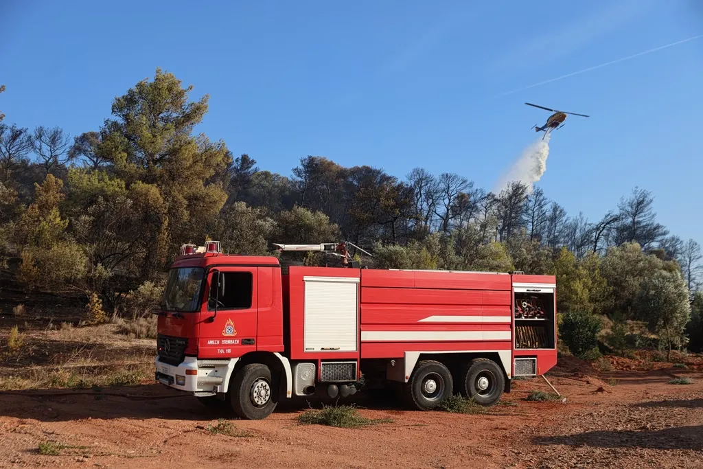 Πυροσβεστικό ελικόπτερο ρίχνει νερό σε δασική φωτιά