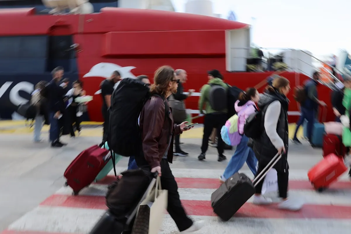 Επιβάτες περιμένουν να επιβιβαστούν σε πλοίο στο λιμάνι του Πειραιά