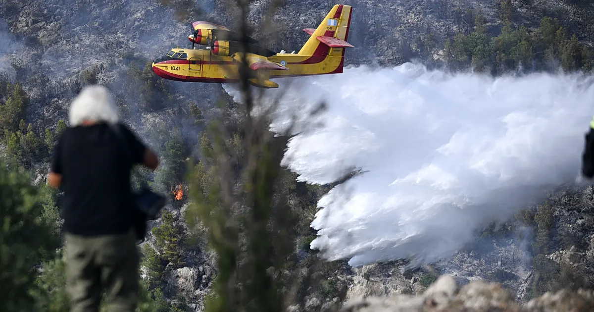 Πυροσβεστικό ελικόπτερο ρίχνει νερό σε δασική πυρκαγιά