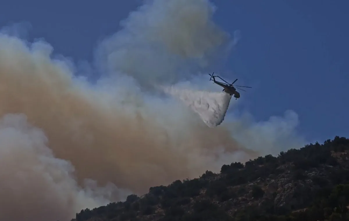 Πυροσβεστικό αεροσκάφος ρίχνει νερό σε δασική φωτιά