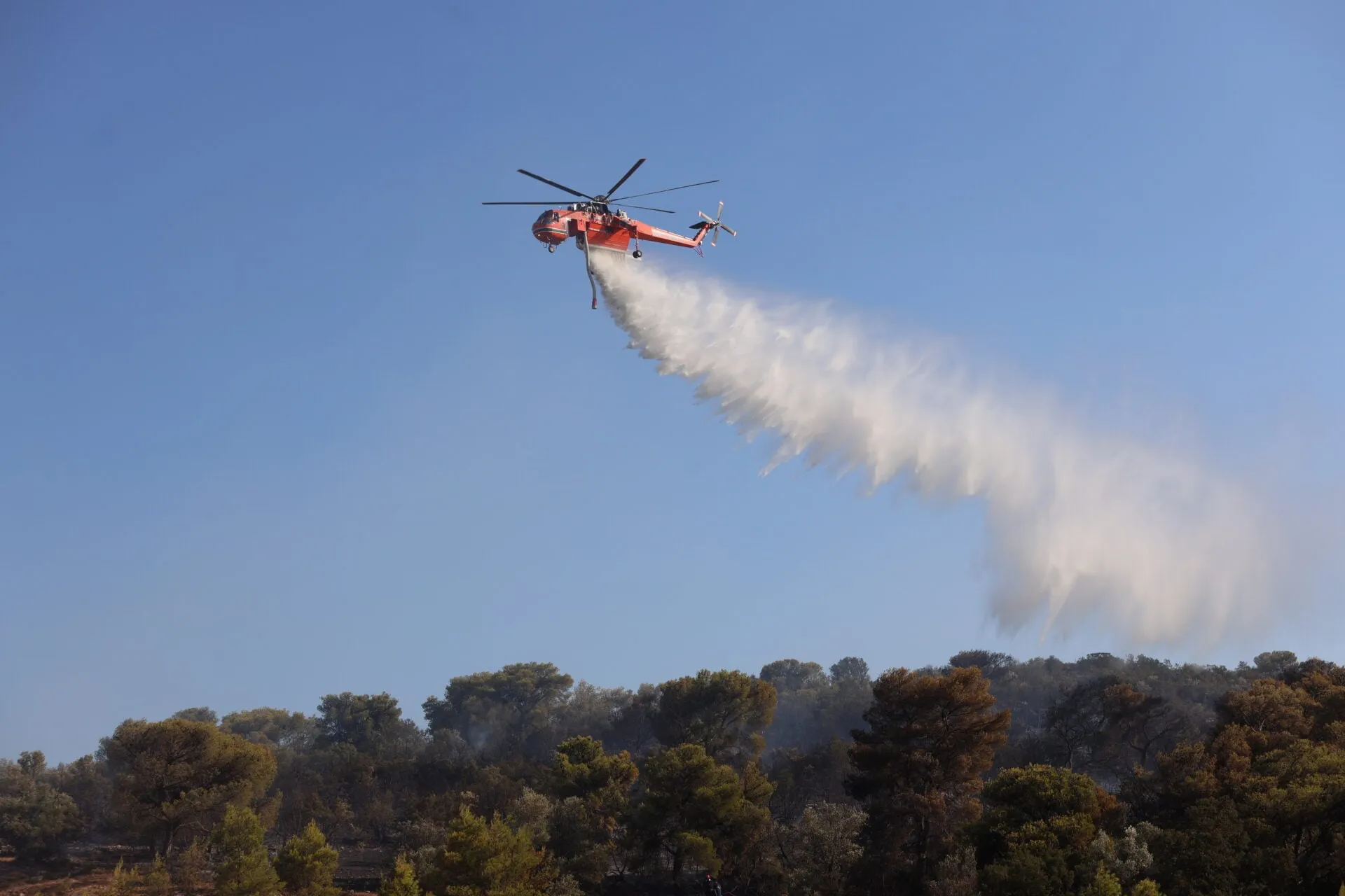 Πυροσβεστικό ελικόπτερο ρίχνει νερό σε δασική πυρκαγιά στη Χαλκιδική