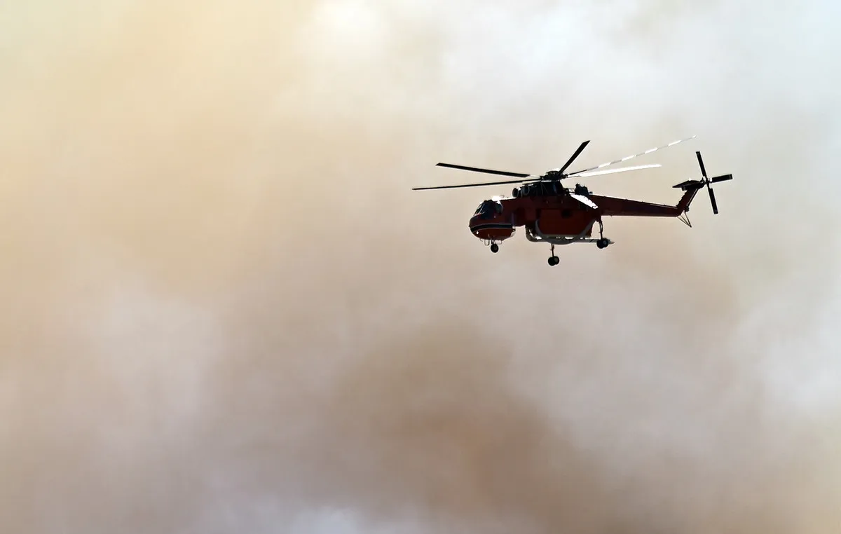 Πυροσβεστικό ελικόπτερο ρίχνει νερό σε δασική πυρκαγιά