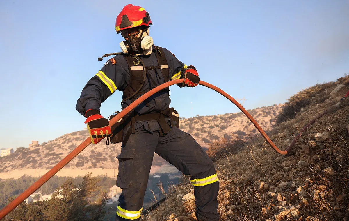 Πυροσβέστες κατά τη διάρκεια κατάσβεσης πυρκαγιάς σε χαμηλή βλάστηση