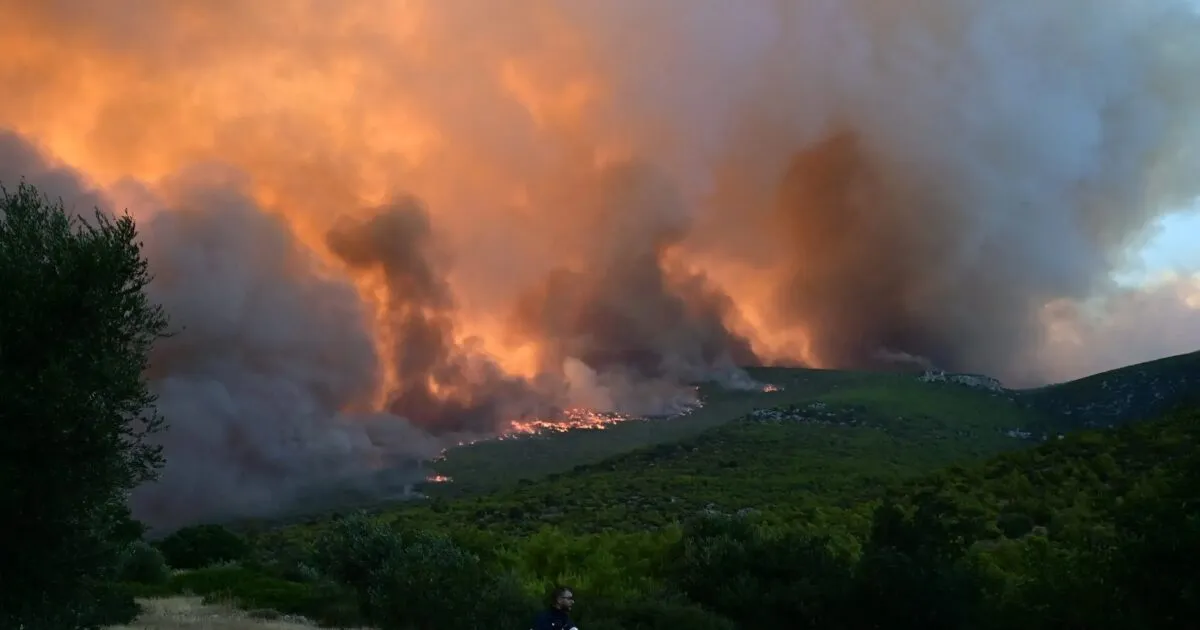 Πυροσβεστικό ελικόπτερο ρίχνει νερό σε δασική φωτιά στα Άγραφα