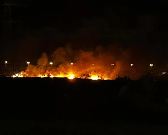 Πυροσβέστες κατασβήνουν φωτιά σε χαμηλή βλάστηση τη νύχτα