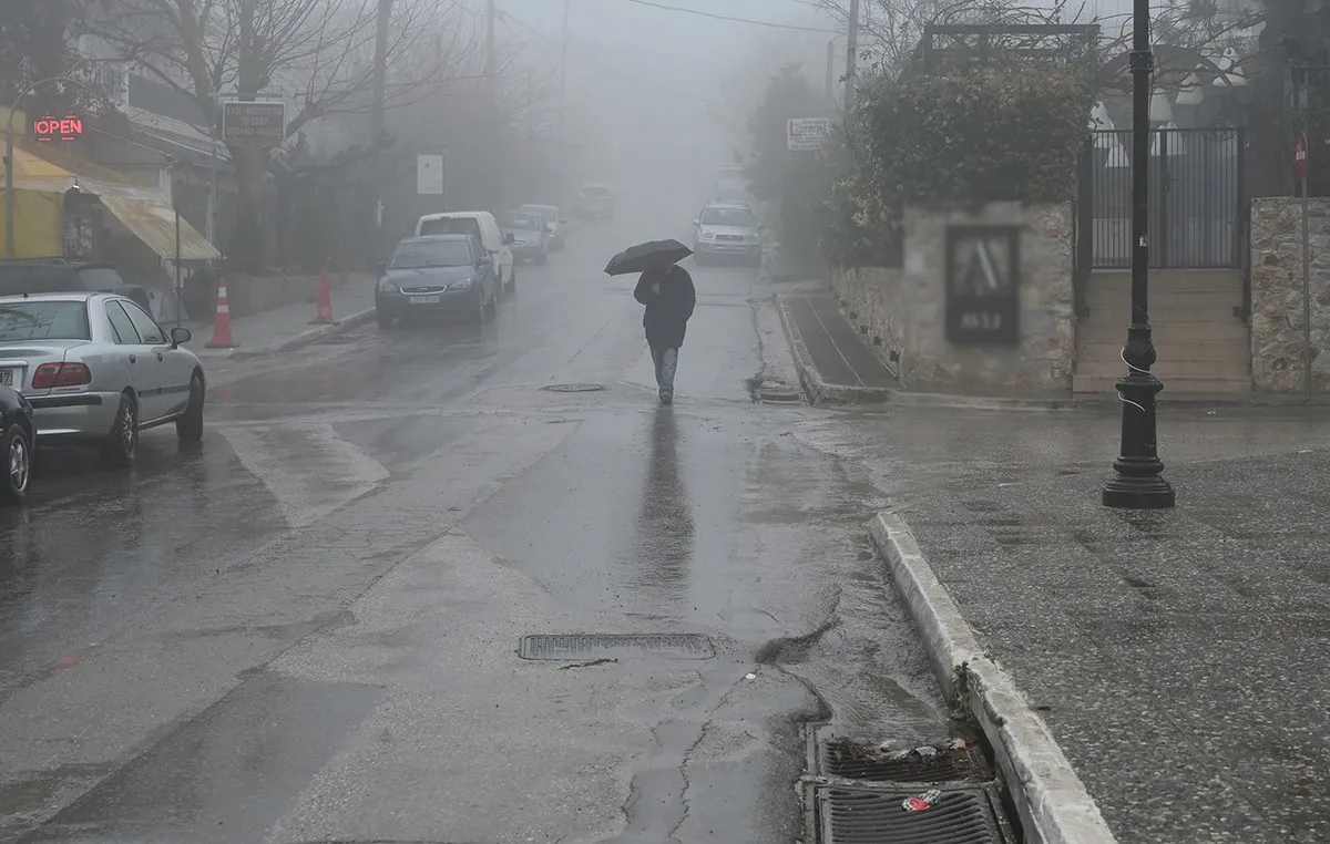 Σύννεφα και καταιγίδα πάνω από ελληνική πόλη