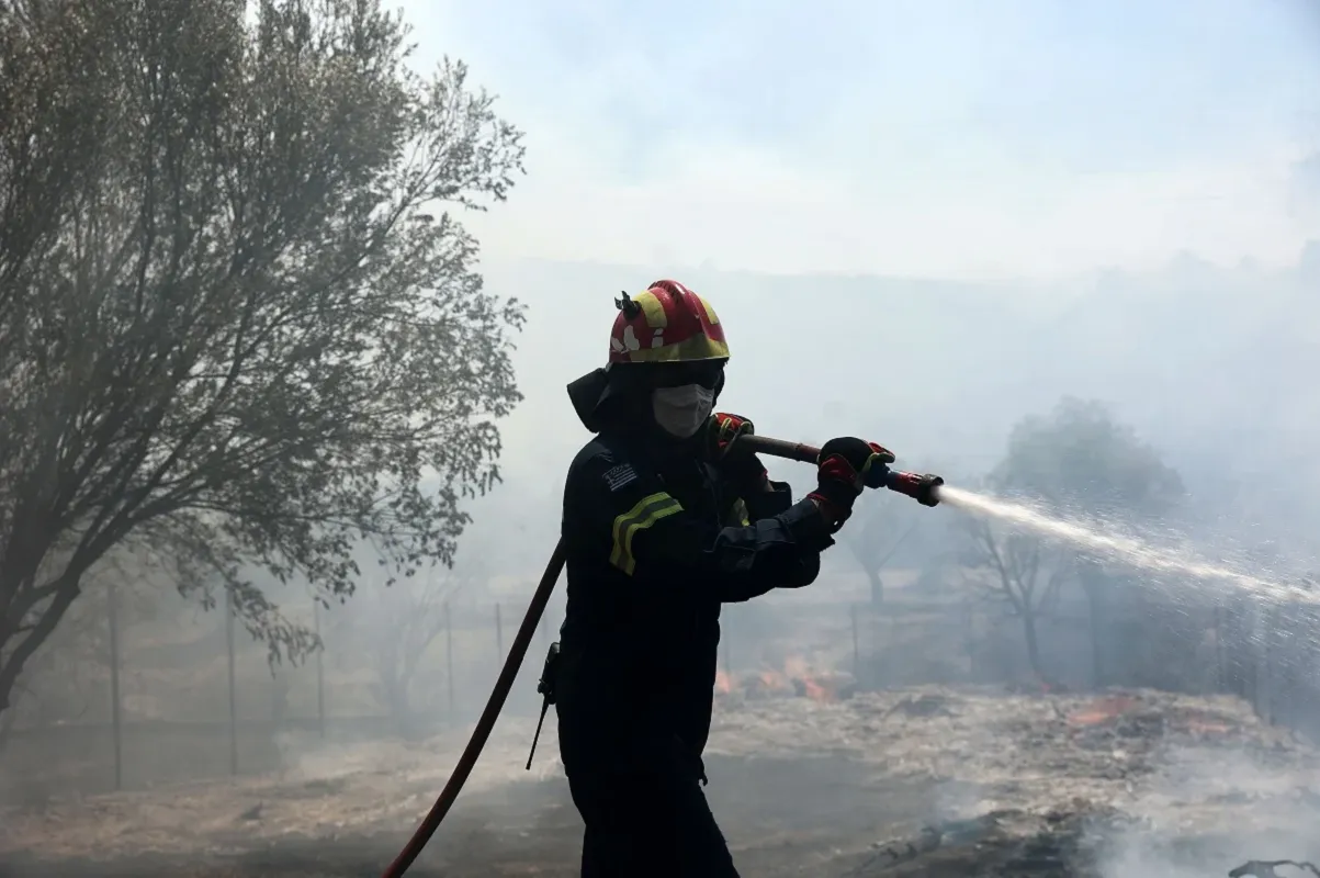 Πυροσβεστικά οχήματα επιχειρούν σε πυρκαγιά σε χαμηλή βλάστηση